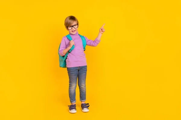 Photo pleine grandeur de charmant petit garçon pointe espace vide recommander des cours d'école isolés sur fond de couleur jaune — Photo