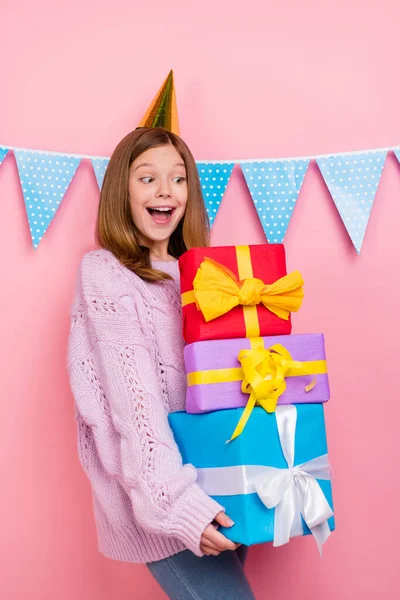 Verticale foto van zoete opgewonden meisje breigoed trui hoofdmode op zoek presenteert stapel geïsoleerde roze kleur achtergrond — Stockfoto