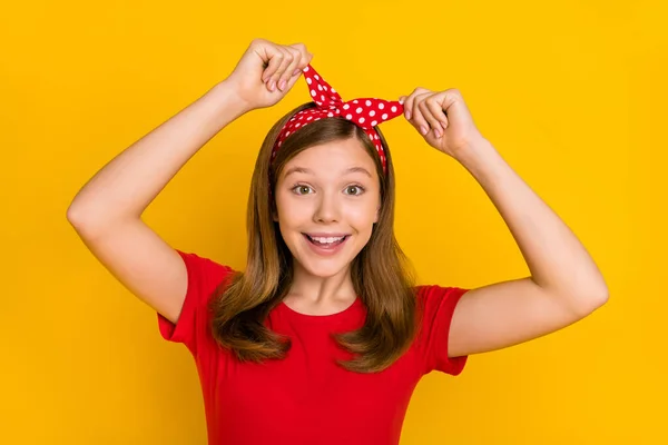 Retrato de boa aparência alegre animado adolescente fêmea ajustar pontilhado impressão headband isolado no fundo de cor amarela — Fotografia de Stock