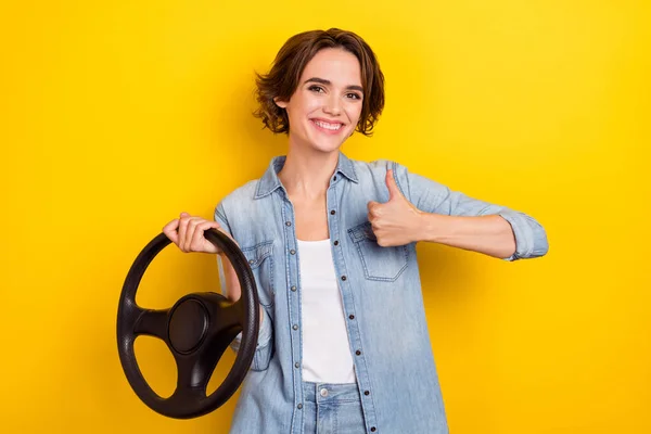 Foto von jungen fröhlichen Frau zeigen Daumen hoch große Anzeigen wählen Transport isoliert über gelben Farbhintergrund — Stockfoto