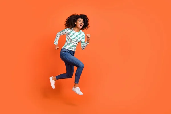 Full body foto van jonge dame run wear shirt jeans sneakers geïsoleerd op oranje achtergrond — Stockfoto
