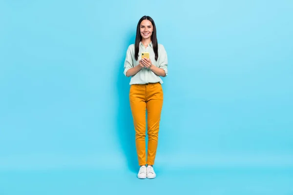 Full length photo of young woman use smartphone repost app download isolated over blue color background — Zdjęcie stockowe