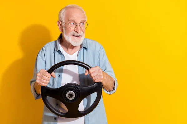 Porträt von attraktiven fröhlichen grauhaarigen Mann fahren Mietauftrag kopieren Raum ad Versicherung isoliert auf lebendigen gelben Farbhintergrund — Stockfoto