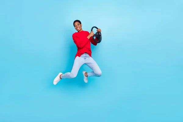 Фото веселой эмоции повседневной одежды прыжки девушки взять уроки вождения держать руль изолированы на синем фоне цвета — стоковое фото