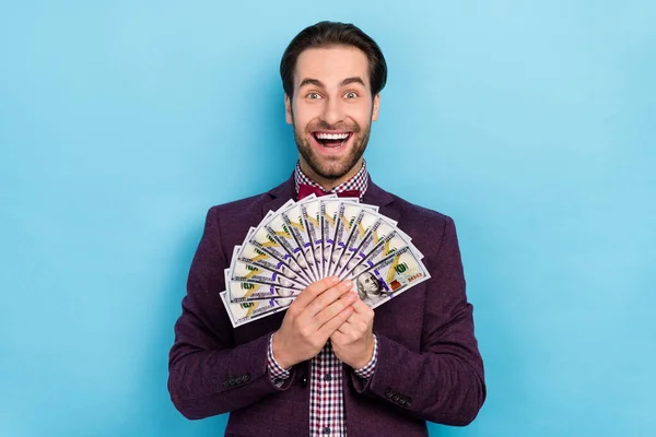 Photo of young excited man hold money salary earnings finance profit isolated over blue color background — Stock Photo, Image