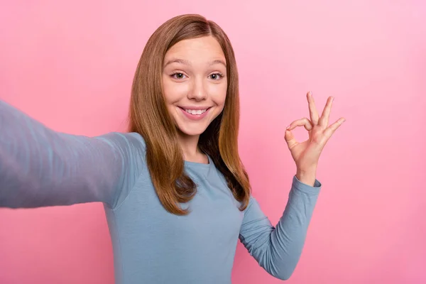 Auto-retrato de atraente alegre moderno engraçado menina de cabelos castanhos mostrando v-sinal isolado sobre cor pastel rosa fundo — Fotografia de Stock