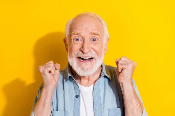 Retrato de atractivo afortunado alegre hombre de pelo gris regocijando gran éxito aislado sobre fondo de color amarillo brillante —  Fotos de Stock