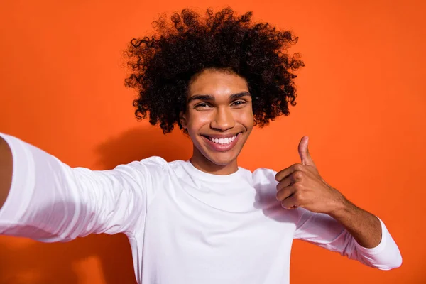 Foto de encantador chico guapo vestido camisa blanca viraje selfie mostrando pulgar hacia arriba fondo de color naranja aislado —  Fotos de Stock