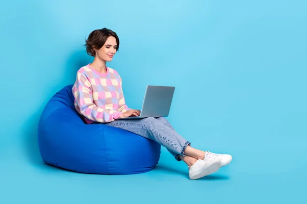 Foto sisi profil tubuh penuh dari gadis muda menggunakan manajer laptop sit beanbag terisolasi dengan latar belakang warna biru — Stok Foto