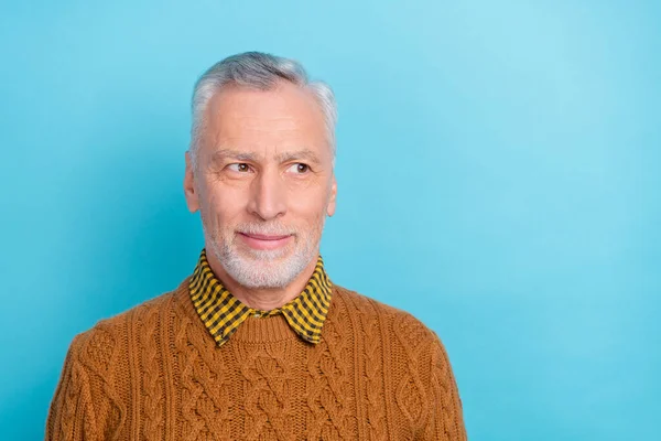 Foto av söt omtänksam man pensionär klädd brun pullover ser tomt utrymme isolerad blå färg bakgrund — Stockfoto