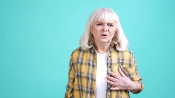 Vovó sofrer dor de coração grave angina isolado fundo cor ciano — Vídeo de Stock