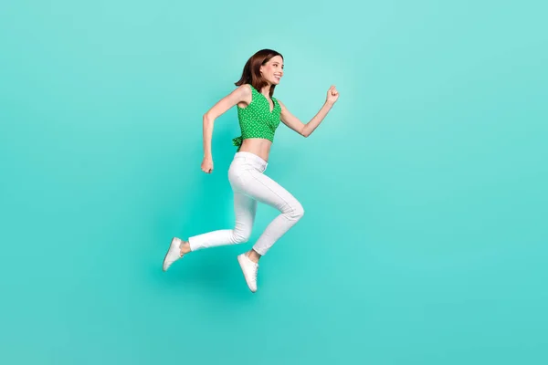 Повнорозмірна фотографія профілю молодої леді стрибає бігун Поспішайте рух ізольовано на бірюзовому кольоровому фоні — стокове фото
