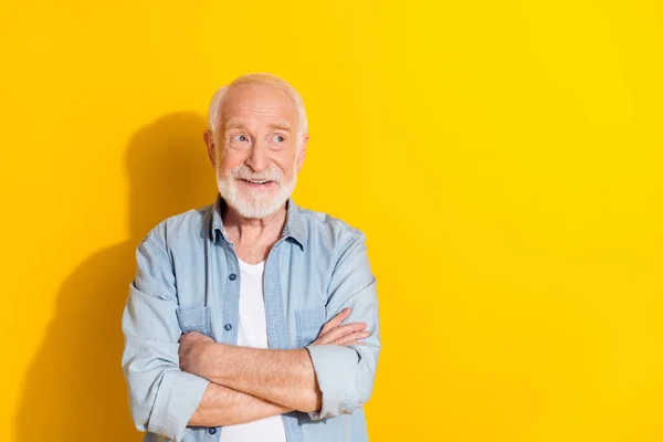 Porträtt av attraktiva glada gråhårig man vikta armar gör lösning isolerad över ljust gul färg bakgrund — Stockfoto