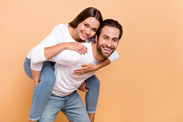 Foto de bonito millennial morena casal abraço jogar desgaste camisa jeans isolado no fundo bege — Fotografia de Stock