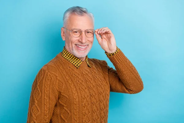 Foto av attraktiv ganska pensionerad man bära brun tröja arm glasögon tomt utrymme isolerad blå färg bakgrund — Stockfoto