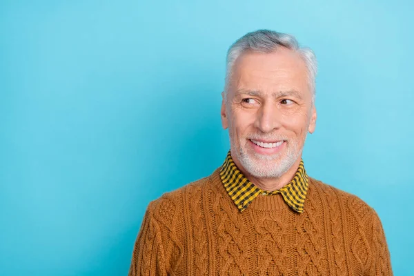 Foto av attraktiva drömmande pensionerad man bära brun tröja ser tomt utrymme isolerad blå färg bakgrund — Stockfoto