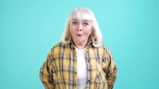Söt mormor imponerade otrolig information isolerad cyan färg bakgrund — Stockvideo
