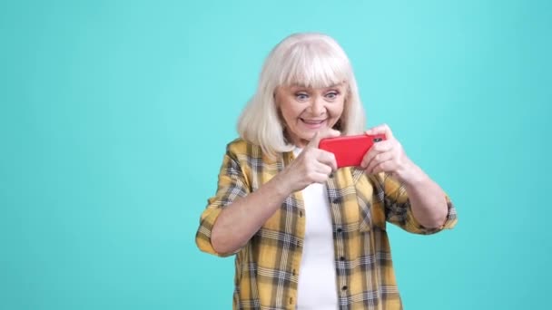 Moderno abuelita jugar tecnología puño hasta éxito aislado cyan color fondo — Vídeo de stock