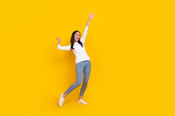 Full size photo of young cheerful woman have fun hang-out look empty space isolated over yellow color background — Stock Photo, Image