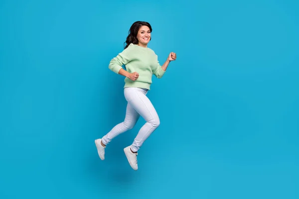 Full storlek profil foto av roliga unga brunett dam springa bära skjorta byxor skor isolerad på blå bakgrund — Stockfoto