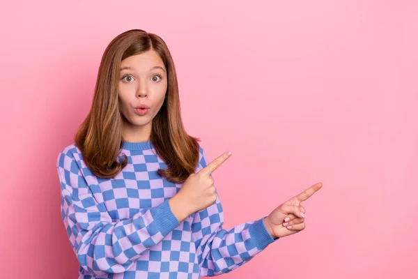 Bild av brun imponerad tonåring flicka visa tomt utrymme slitage rutig pullover isolerad på rosa färg bakgrund — Stockfoto