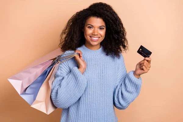 Genç, güzel kız mağazasının kredi kartı gelirinin fotoğrafı bej rengi arka planda izole edilmiş. — Stok fotoğraf