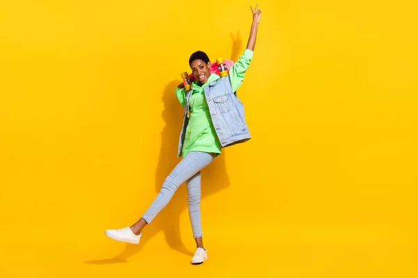 Ganzkörperporträt von lustigen Youngster Skatefingern demonstrieren V-Zeichen freundlich isoliert auf gelbem Hintergrund — Stockfoto
