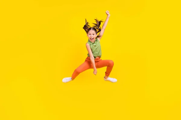 Foto van funky charmante tiener meisje gekleed groen top springen hoog paardrijden gooien lasso glimlachen geïsoleerde gele kleur achtergrond — Stockfoto