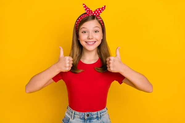 Foto van mooie kleine meisje duim omhoog dragen hoofdband rood t-shirt geïsoleerd op levendige gele kleur achtergrond — Stockfoto