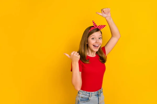 Foto de bonito alegre animado pouco menina apontar dedos vazio espaço anúncio isolado no fundo cor amarela — Fotografia de Stock