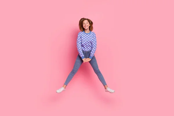 Foto em tamanho completo de loira menina salto desgaste camisola jeans tênis isolado no fundo rosa — Fotografia de Stock