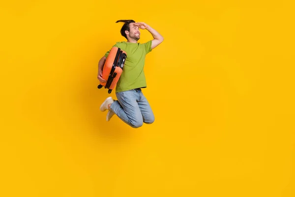 Ganzkörperprofil Seite Foto von jungen Mann Pullover suchen leeren Raum Koffer Tourismus isoliert über gelbe Farbe Hintergrund — Stockfoto