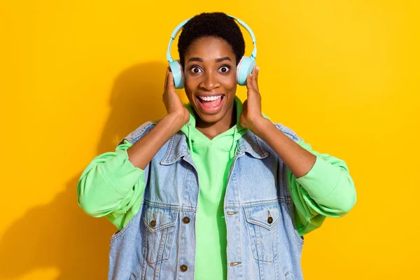 Portret van aantrekkelijke vrolijke brunet meisje luisteren verschillende hit single geïsoleerd over helder gele kleur achtergrond — Stockfoto