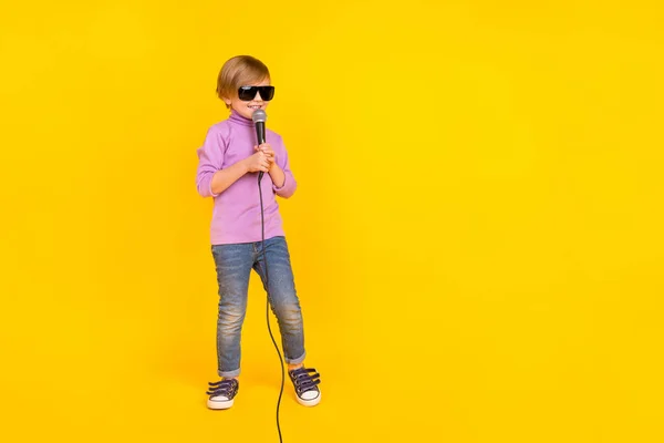 Full size foto di allegro divertente piccolo ragazzo futuro famoso cantante tenere mic canto canzone isolato su sfondo di colore giallo — Foto Stock