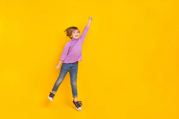 Plná velikost fotografie dobré nálady roztomilý chlapec létání držení neviditelný slunečník izolované na žluté barvy pozadí — Stock fotografie