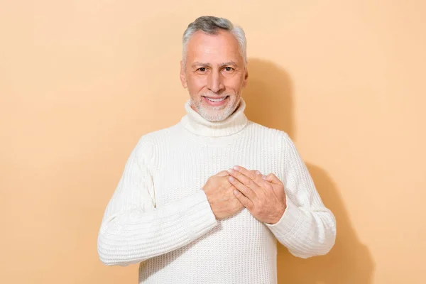 Portrait d'homme joyeux et joyeux aux cheveux gris touchant des sentiments cardiaques isolés sur fond beige couleur pastel — Photo