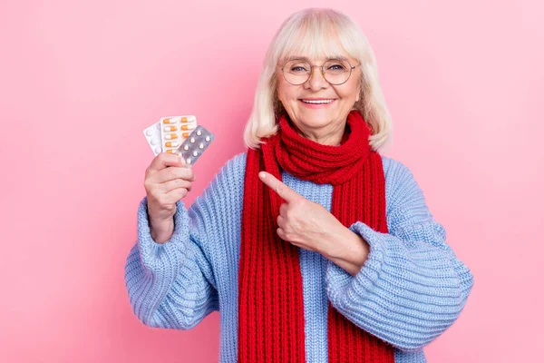 Foto della donna anziana indicano compresse di droga dito raccomandare promo isolato su sfondo di colore rosa — Foto Stock