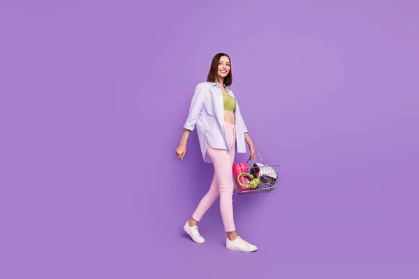 Foto de perfil de longitud completa de funky morena millennial lady go wear top shirt jeans sneakers isolated on violet background —  Fotos de Stock