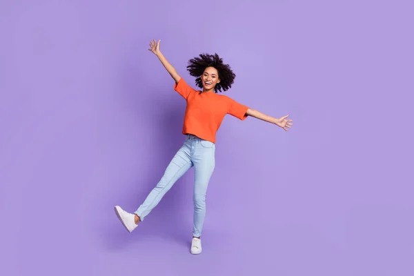 Фотография в полный рост симпатичной девушки, танцующей на фоне фиолетового цвета — стоковое фото
