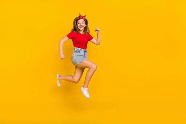 Foto em tamanho completo de impressionado menina adolescente executar desgaste t-shirt hairband saia calçado isolado no fundo amarelo — Fotografia de Stock