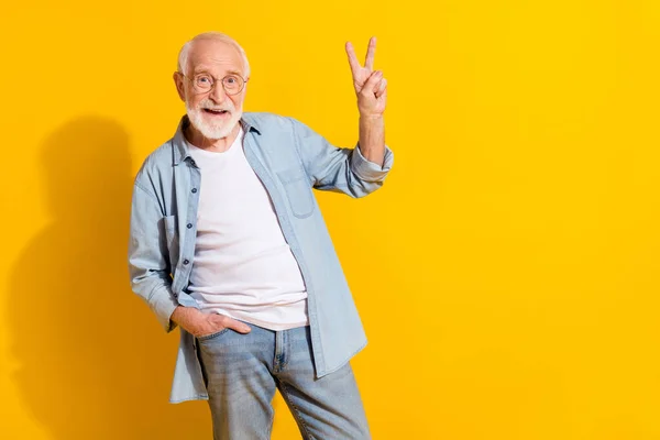 Retrato de atraente funky alegre homem de cabelos grisalhos mostrando v-sinal bom humor isolado sobre fundo de cor amarelo brilhante — Fotografia de Stock