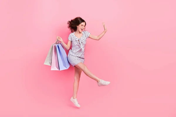 Фотографія повного розміру весела божевільна дівчина, що стрибає, йде за покупками на чорну п'ятницю ізольовано на рожевому кольоровому фоні — стокове фото