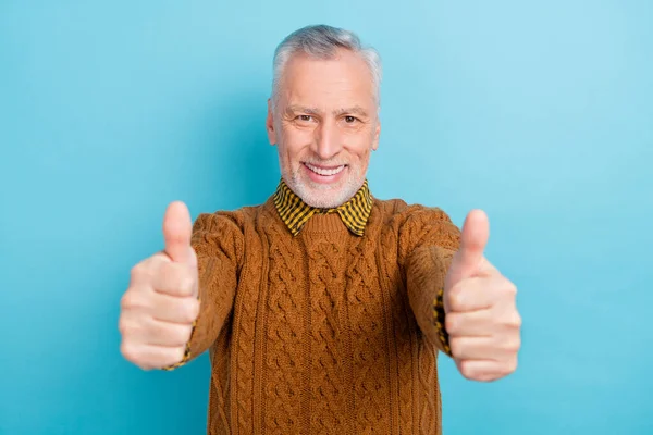 Φωτογραφία με αυτοπεποίθηση ελκυστικός συνταξιούχος ντυμένος καφέ πουλόβερ δείχνει αντίχειρες επάνω απομονωμένο φόντο μπλε χρώμα — Φωτογραφία Αρχείου