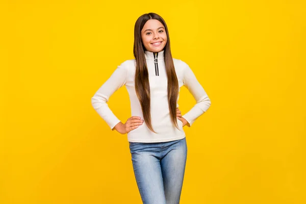 Foto de encantadora niña preadolescente brillante vestida con cremallera blanca brazos cintura sonriente aislado color amarillo fondo — Foto de Stock