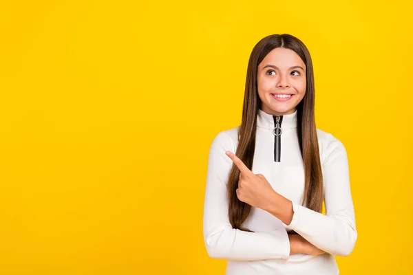 Foto van dromerig glanzend student meisje dragen witte rits shirt glimlachen wijzende vinger lege ruimte geïsoleerde gele kleur achtergrond — Stockfoto