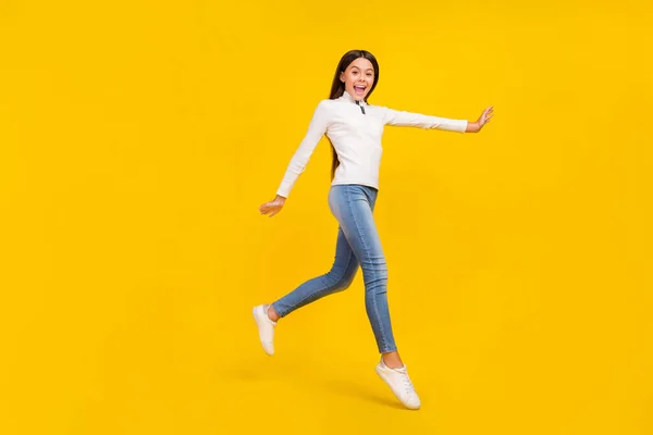Foto de comprimento total de impressionado morena menina correr desgaste branco pulôver jeans tênis isolado no fundo de cor amarela — Fotografia de Stock