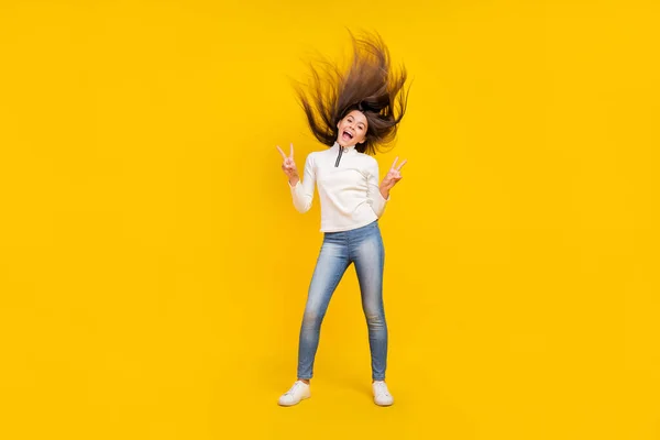 Полное фото тела прохладной брюнетки девушка-подросток показать V-знак носить белый свитер джинсы кроссовки изолированы на желтом фоне цвета — стоковое фото