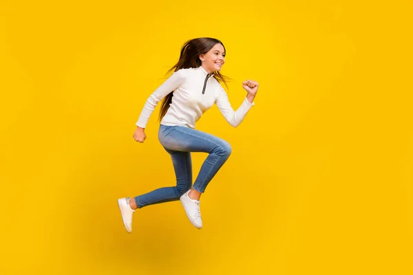 Повний профіль тіла фото милої брюнетки підліток дівчина біжить носити светр джинси взуття ізольовані на жовтому тлі — стокове фото