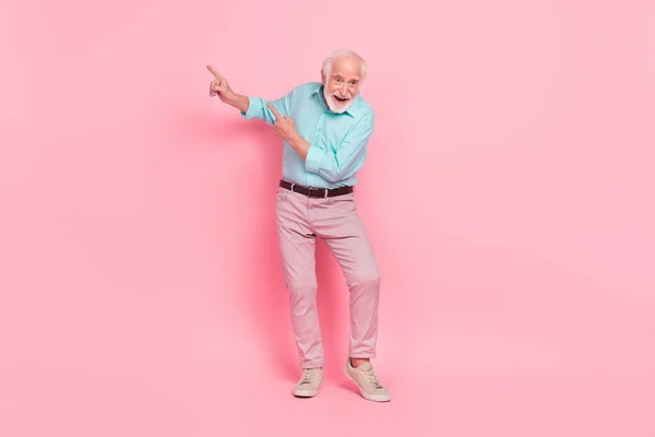 Full body foto van energetische middelbare leeftijd bewegende discotheek punt hand lege ruimte geïsoleerde pastel kleur achtergrond — Stockfoto