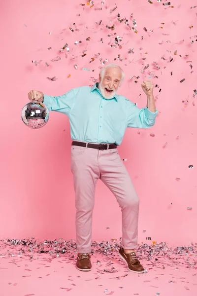 Vertikalt foto av glada eleganta trendiga mannen hålla glödande boll nävar upp isolerade pastell färg bakgrund — Stockfoto